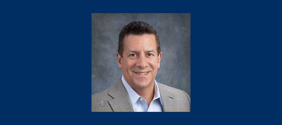 David Latta pictured wearing a grey suit jacket and white collared shirt.