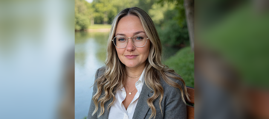 Anna Davis, Operations Manager at ACRT Services, wearing glasses, a navy blazer, and white top, smiling outdoors with greenery in the background.